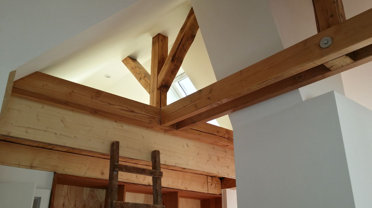 Innenausbau im Dachgeschoss mit sichtbarem Holzgebälk