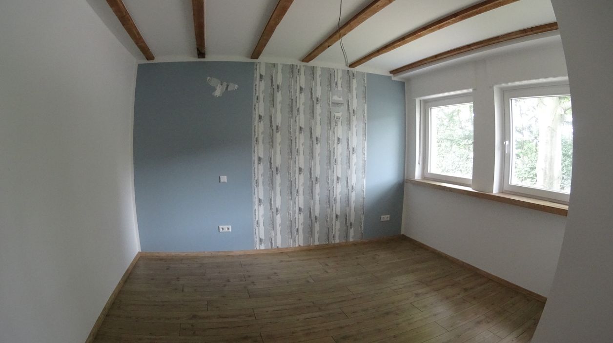 Zimmer mit blauer Wand und Designtapete